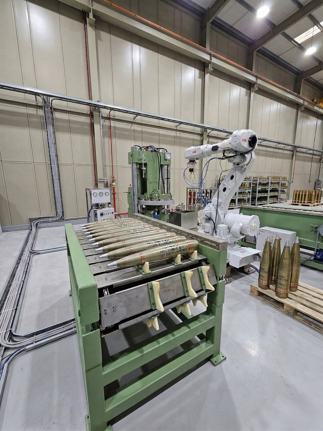 ABB robot handling artillery shells on roller conveyor